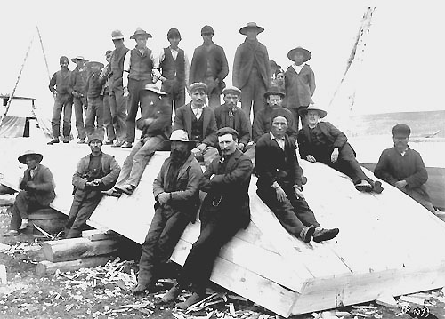 Boatbuilders, including native men at Athabasca Landing, with a newly built scow ready to leave for the klondike.