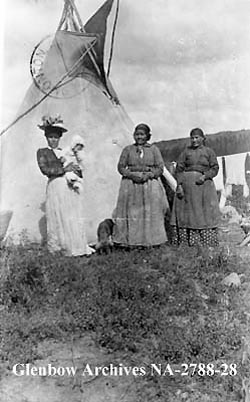 Cree women being visited by a white lady, Athabasca Landing, 1912