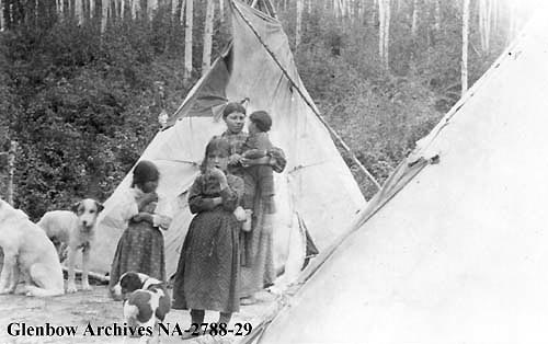 Cree family in Indian camp on the outskirts of Athabasca Landing, 1912.